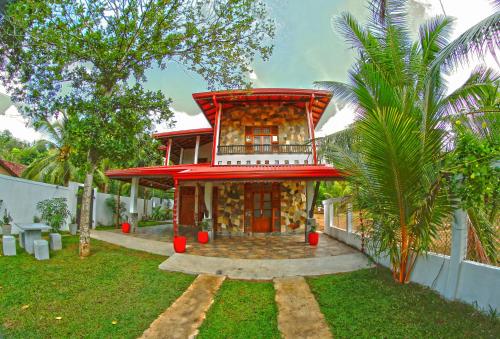 a house with a red roof and a yard at Grand Residence in Tangalle