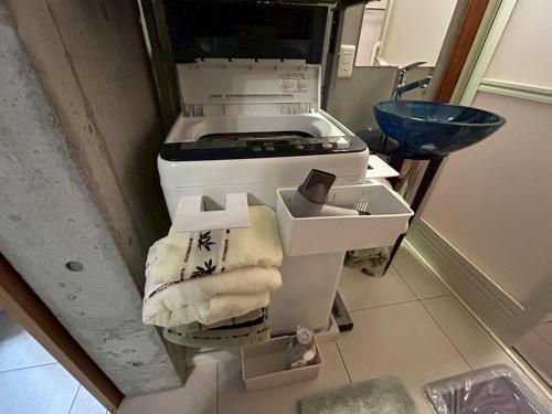 a kitchen with a stove and a sink at オランウータンApple House Ginowan in Ginowan
