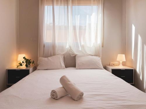 ein Schlafzimmer mit einem weißen Bett und einem Fenster in der Unterkunft וילת אתרוג - וילה וצימר מושלמים עם בריכה באשלים in Ashalim