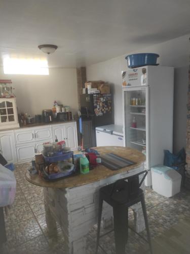 a kitchen with a table and a refrigerator at Koa's Beach House in Tangalan