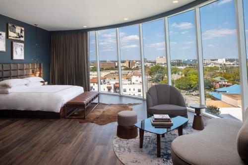 a bedroom with a bed and a view of a city at Thompson San Antonio - Riverwalk, by Hyatt in San Antonio