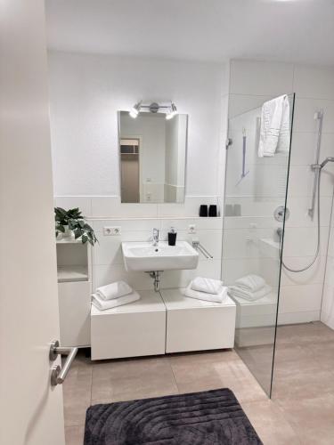 a white bathroom with a sink and a shower at SeePERLE 131 in Friedrichshafen