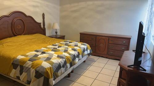 a bedroom with a bed and a dresser and a tv at Not for rent in Mazatlán