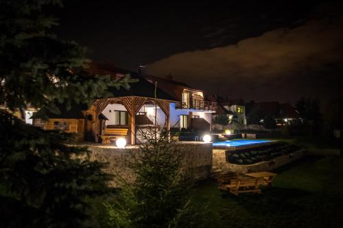 a house at night with a swimming pool at Apartamenty Pod Łysicą & SPA - przy stoku, basen, jacuzzi, sauna in Krajno Pierwsze