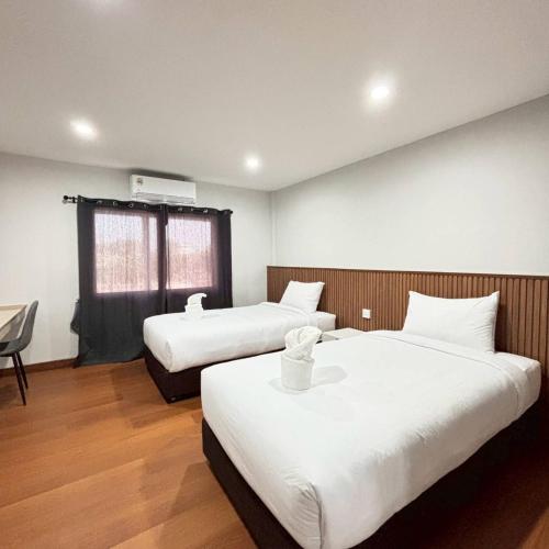a hotel room with two beds and a chair at Ma Relax Place in Ban Hau Chang