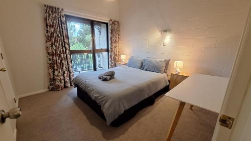 a bedroom with a dog laying on a bed at Relax on Robertson in Queenstown