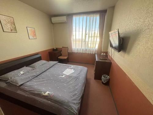 a small room with a bed and a window at ホテルルネサンス土浦 in Tsuchiura
