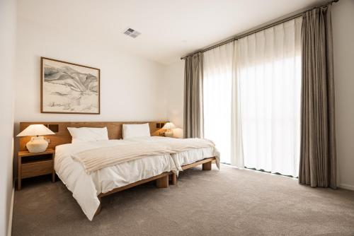 a bedroom with a bed and a large window at Shining House Villa A in Tanunda