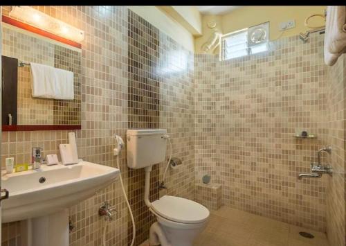 a bathroom with a toilet and a sink at Daffodil Suites, Manyata Tech Park, Bengaluru in Bangalore