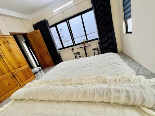 a large bed in a room with a large window at Lùma Sapa Homestay in Sapa