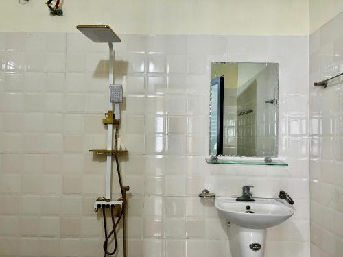 a white bathroom with a sink and a mirror at Lùma Sapa Homestay in Sapa