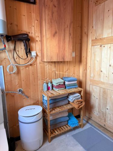 a bathroom with a toilet and a stack of towels at Islandzka chatka- Jacuzzi i sauna w cenie in Mżyki