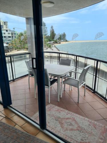 a table and chairs on a balcony overlooking the water at Waterfront Apartments Caloundra in Caloundra
