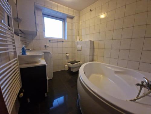 a bathroom with a tub and a toilet and a sink at W1-3 Messe Monteurzimmer Köln in Cologne