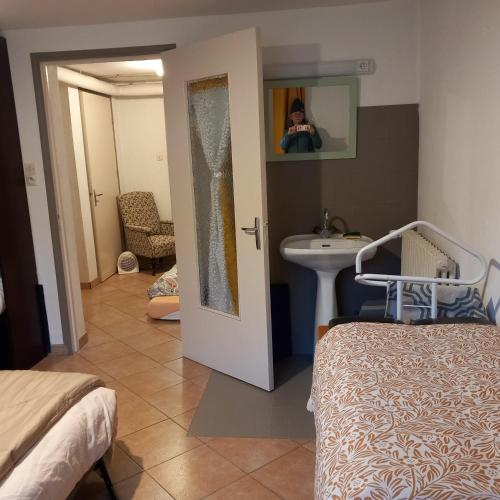 a woman taking a picture of a bathroom with a sink at Vive le vert pomme ! in Saint-Romain-sur-Vienne