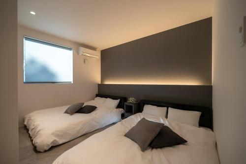 a bedroom with two beds and a window at Seven Saunas Village in Arao