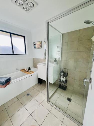 a bathroom with a shower and a tub and a sink at The Baker's Bed - Private 2 King BR Guest Suite in Orange