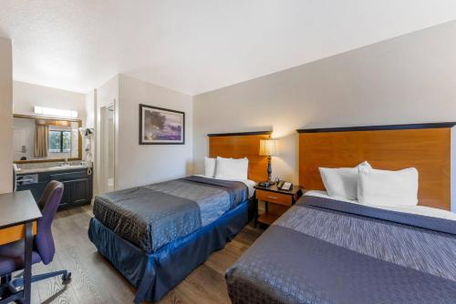 a hotel room with two beds and a desk at Rodeway Inn at Nevada State Capitol in Carson City