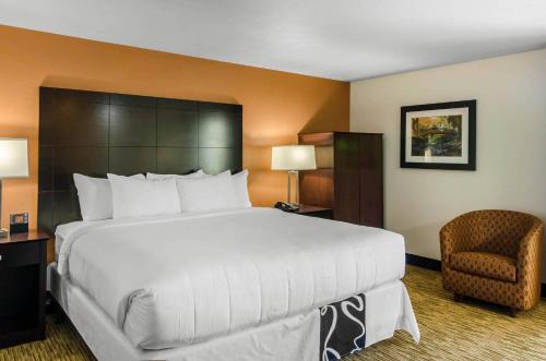 a hotel room with a large bed and a chair at Comfort Inn & Suites Ashland in Ashland