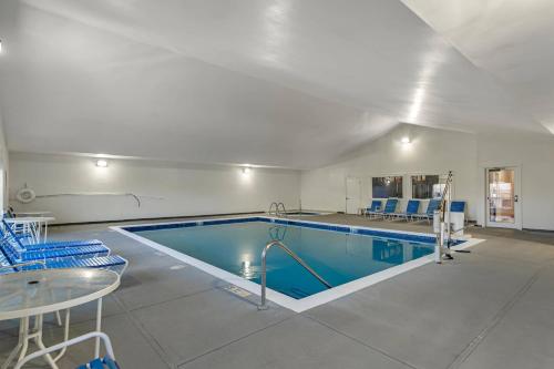 a large swimming pool in a room with a table and chairs at Comfort Inn & Suites Ocean Shores in Ocean Shores