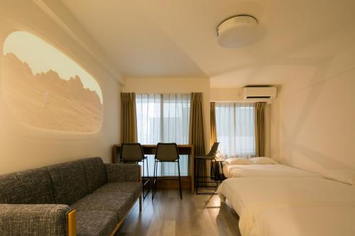 a hotel room with two beds and a couch at trive meieki nishi 101 最大6名宿泊可 名古屋駅まで1駅 太閤通駅徒歩4分 in Nagoya