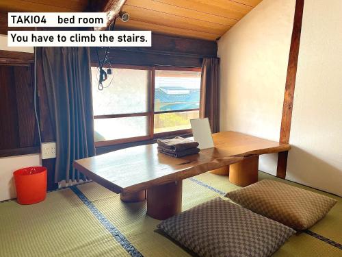 a room with a wooden table and a window at TAKIO 4 guesthouse in Higashi-osaka