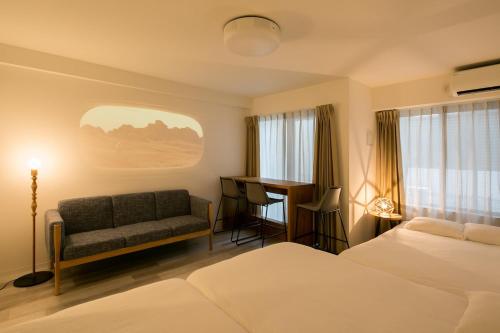 a hotel room with a bed and a couch and a desk at trive meieki nishi 101 最大6名宿泊可 名古屋駅まで1駅 太閤通駅徒歩4分 in Nagoya