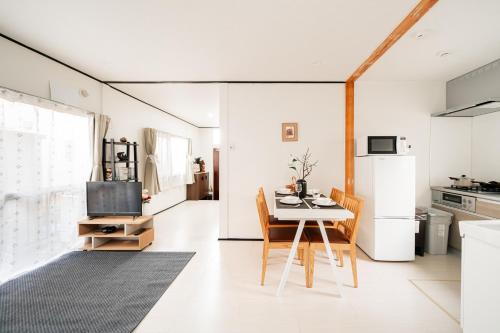 a kitchen and dining room with a table and a refrigerator at New Super Deals Now Available Direct Access to Akihabara Shinjuku and Disneyland in Tokyo