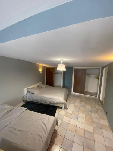 a bedroom with two beds and a ceiling at Les Bruyères in Martigues