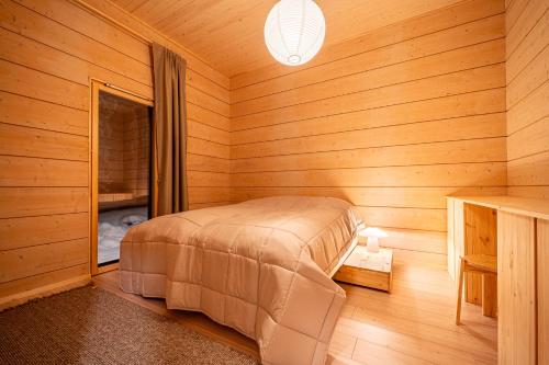 a bedroom with a bed in a wooden room at Lakeside Cabin in Romakkaniemi