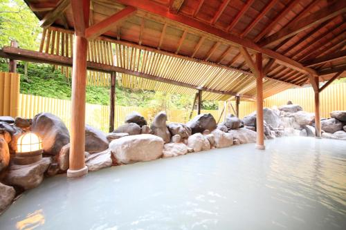 a group of rocks lined up next to a pool of water at Park Hotel Miyabitei in Noboribetsu
