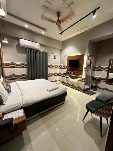 a bedroom with a bed and a tv and a chair at Royal Palm Inn in Jāmb