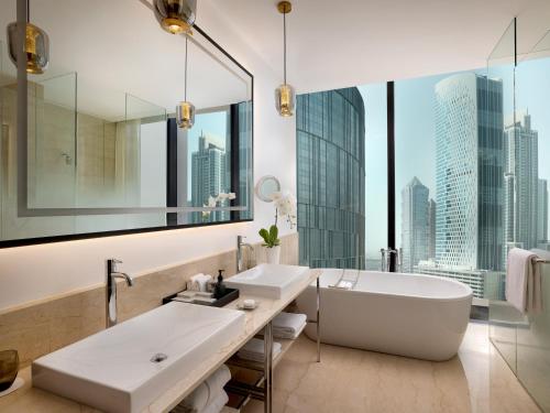 a bathroom with a large white tub and a large window at Anantara Downtown Dubai in Dubai
