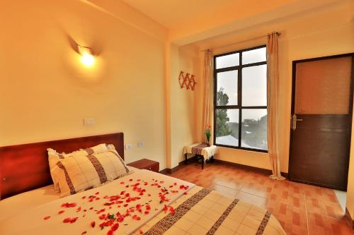a bedroom with a bed with red flowers on it at Budget Gest House in Lalibela