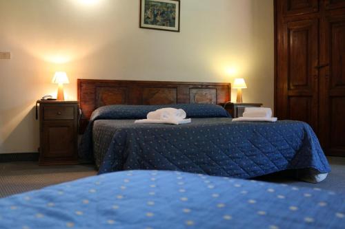 a hotel room with two beds with towels on them at Hotel La Quiete in Bardonecchia