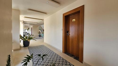 a hallway with a wooden door and a rug at Stellar 23 Resort in Whitefield