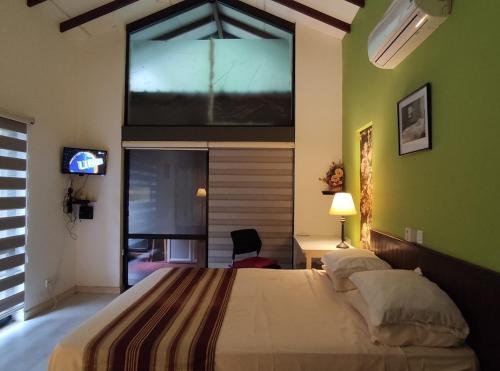 a bedroom with a large bed with a large window at Mi casa in Kandy