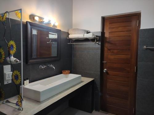 a bathroom with a white sink and a mirror at Mi casa in Kandy