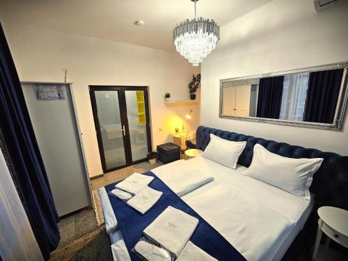 a bedroom with a large bed and a chandelier at Perfect Ploiesti in Ploieşti