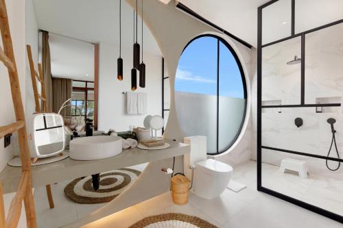 a bathroom with a sink and a toilet and a mirror at Baliwood Residence Villas by BREIG in Munggu