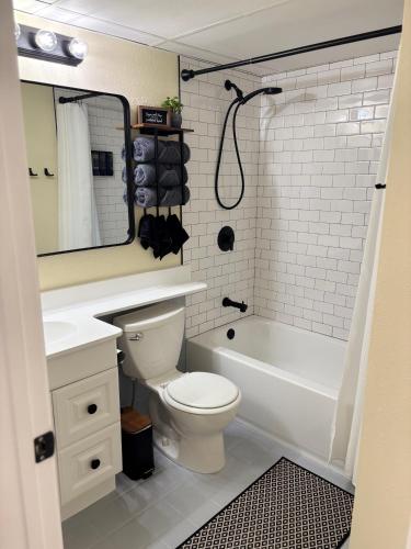 a bathroom with a toilet and a tub and a sink at Boltons Bungalow Casa Del Mar in Galveston