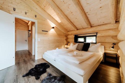 a large white bed in a wooden room at Luxury Chalet near Ski Slopes in Jenig