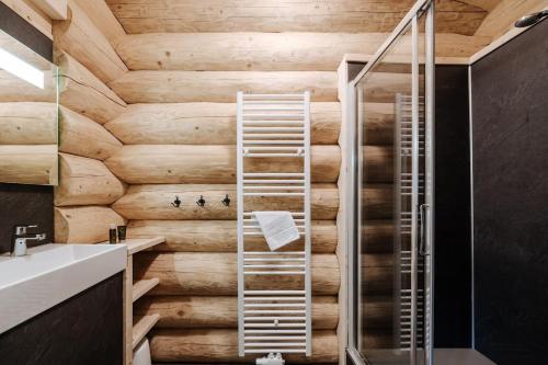 a bathroom with a wooden wall and a shower at Luxus Chalet nähe Skipiste in Jenig