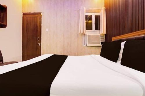 a large white bed in a room with a window at RROOMS Eco Hotel Blue Stone- Near Singapore Mall And Max Hospital in Lucknow