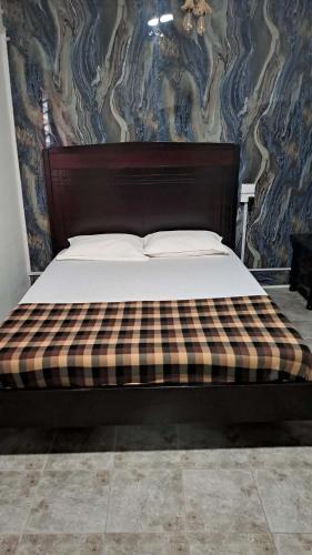 a bedroom with a bed with a plaid mattress at Dream Paradise Apartment in Korotogo