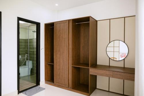 a bathroom with wooden cabinets and a mirror at Cloud Inn Homestay in Thôn Lại Thê