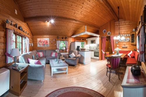 a living room with a couch and chairs in a cabin at Schwedenhaus Uplandalm Willingen in Bömighausen