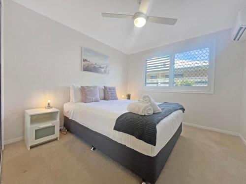a bedroom with a bed with a night stand and a window at Coastal retreat, private, wine, netflix by Custom Bnb Hosting in Buddina
