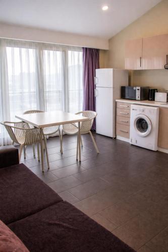 a living room with a table and a kitchen with a washing machine at Diplomat Suites Hotel in Baku