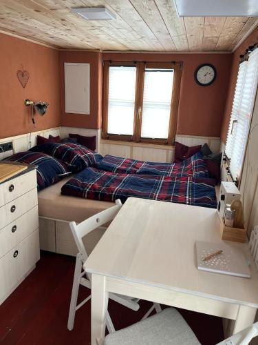 a bedroom with a bed and a desk and a table at Lovingly renovated 120-year-old train car! in Ramsau am Dachstein